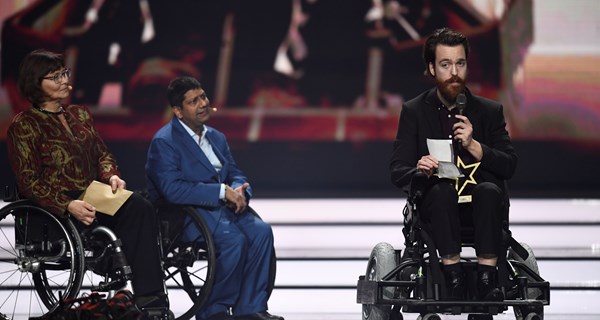 Anders Berenth på scenen. Til venstre sidste års vindere af prisen, Connie Hansen og Mansoor Siddiqi. Foto: Lars Møller.