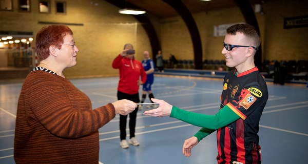 Mona Wejlgaard overrækker donationen på 3.000 kr. til Denis Prce fra Skjern, der er en af de syv udtagne Special Olympics-spillere, der skal repræsentere Danmark i herrehåndbold ved Special Olympics World Games i Berlin i 2023. Foto: Thomas Sjørup.