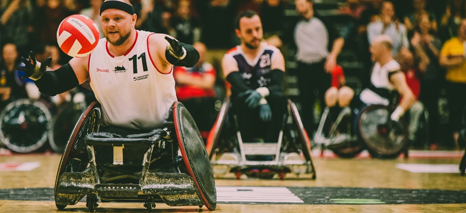 Kørestolsrugbylandsholdets Mark Peters har bolden foran en fransk spiller. Foto: Lars Emil Egeberg Simonsen