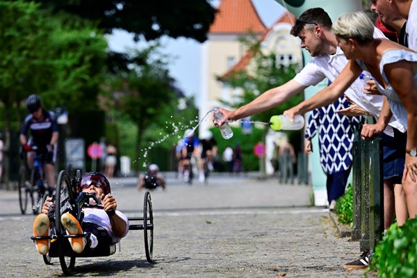 Tilskuere køler en håndcykelrytter af i varmen under enkeltstarten. Foto: Lars Møller.